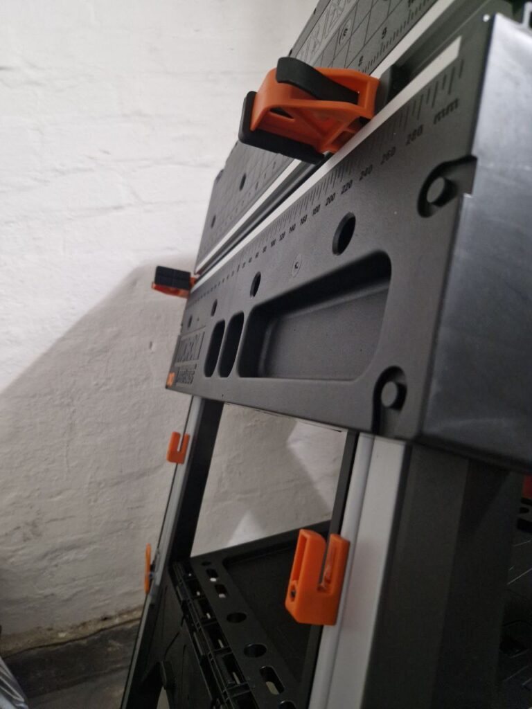 This is a close up photo of the workbench my man tied me to. It is in it's collapsed A-frame form and is pictured against a bare-brick white-washed wall.